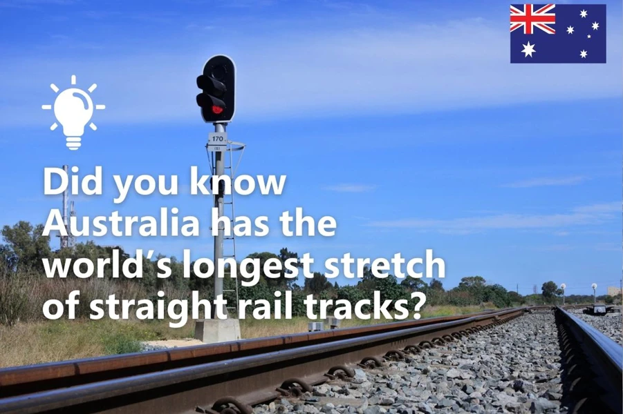 Railway tracks in Australia with a signal light and text stating 'Did you know Australia has the world's longest stretch of straight rail tracks?' accompanied by the Australian flag in the corner